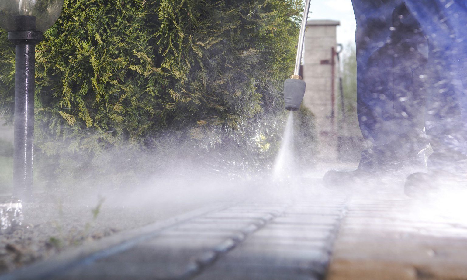 We Hurt Dirt pressure washing a commercial storefront walkway